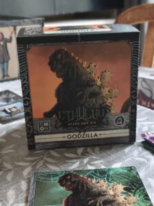 Boîte de jeu Godzilla dans l'extension Cthulhu pour Death May Die, illustrée avec Godzilla et des éléments de monstres mythiques.