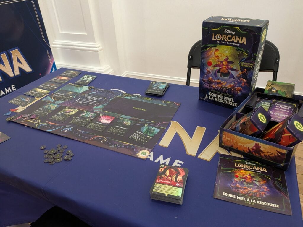 Jeu de cartes Disney Lorcana avec boîte, cartes et jetons sur une table lors d'un événement.