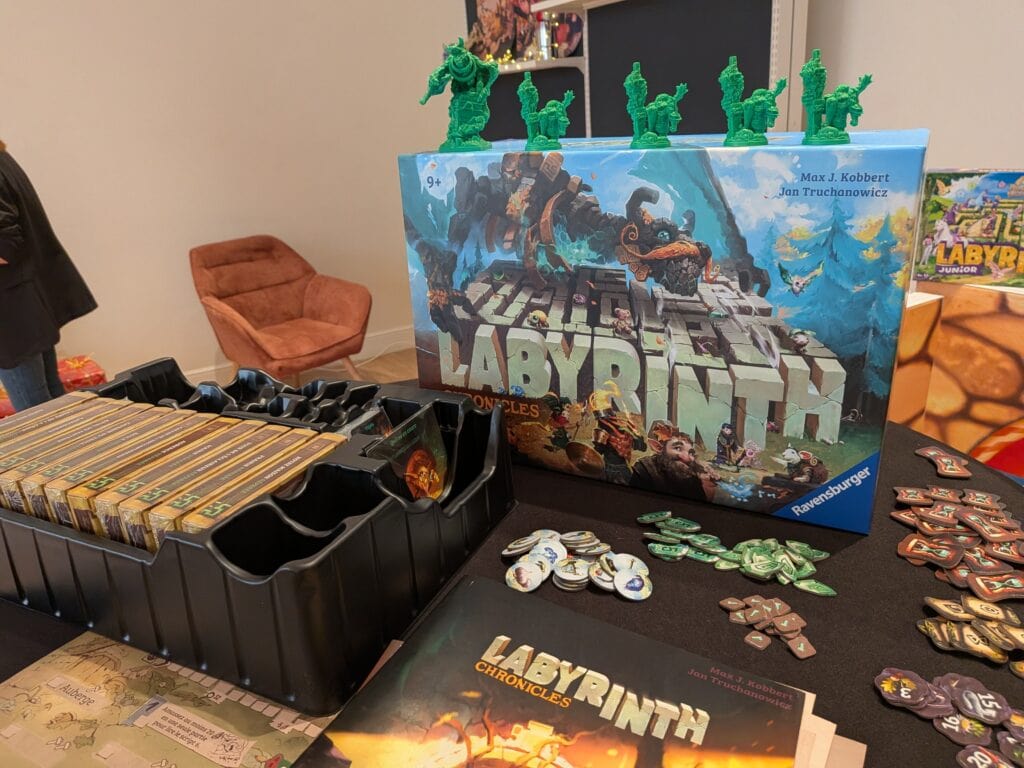 Présentation du jeu Labyrinthe avec figurines en plastique vert et pièces de jeu variées lors d'une exposition.