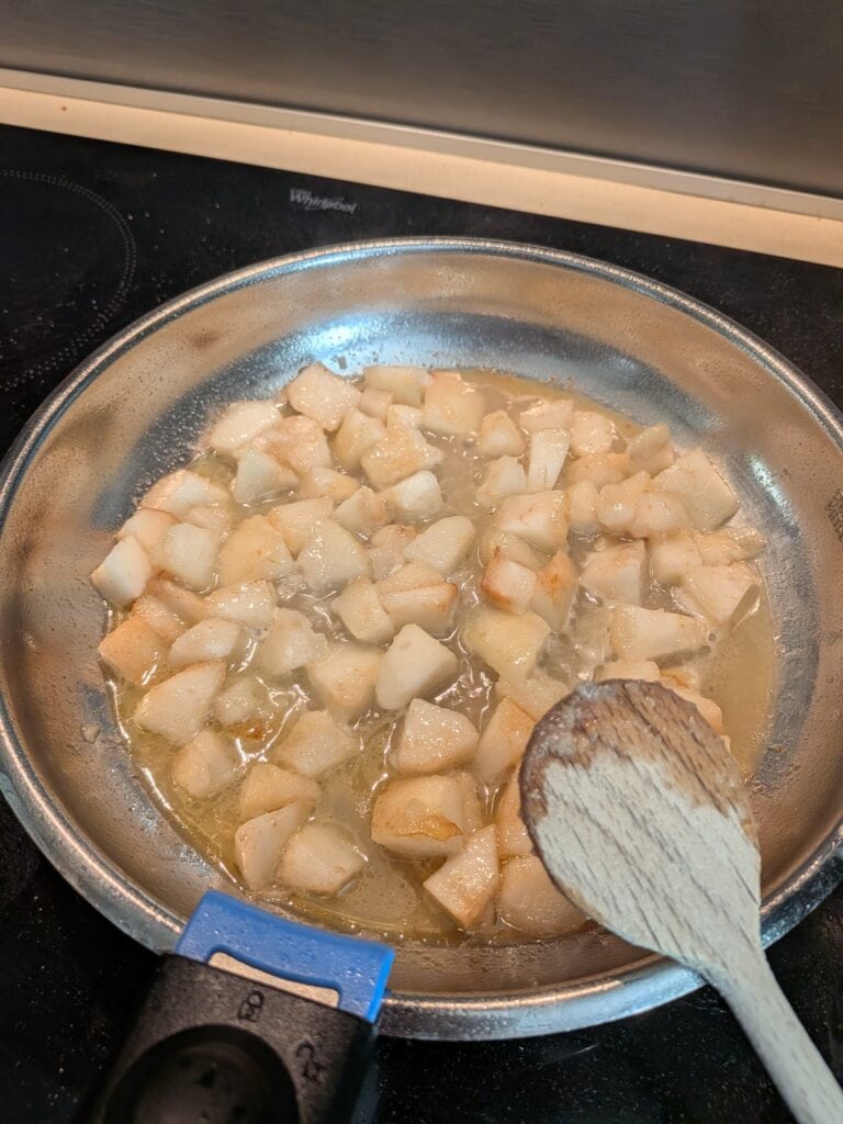 Dés de poisson en train de cuire dans une poêle avec de l'huile, en cours de préparation culinaire.