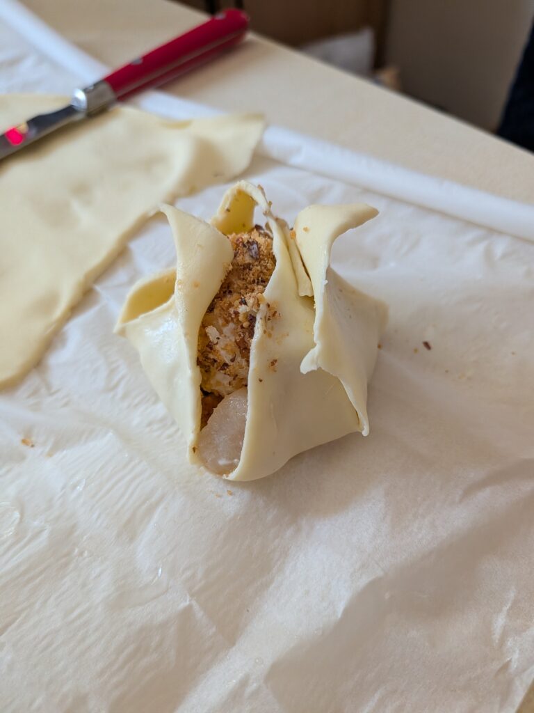 Gâteau en cours de préparation avec pâte à tarte et garniture visible, sur un plan de travail en cuisine.