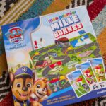 Jeu de société Mon Premier Mille Bornes pour enfants, avec personnages Paw Patrol, sur tapis coloré.