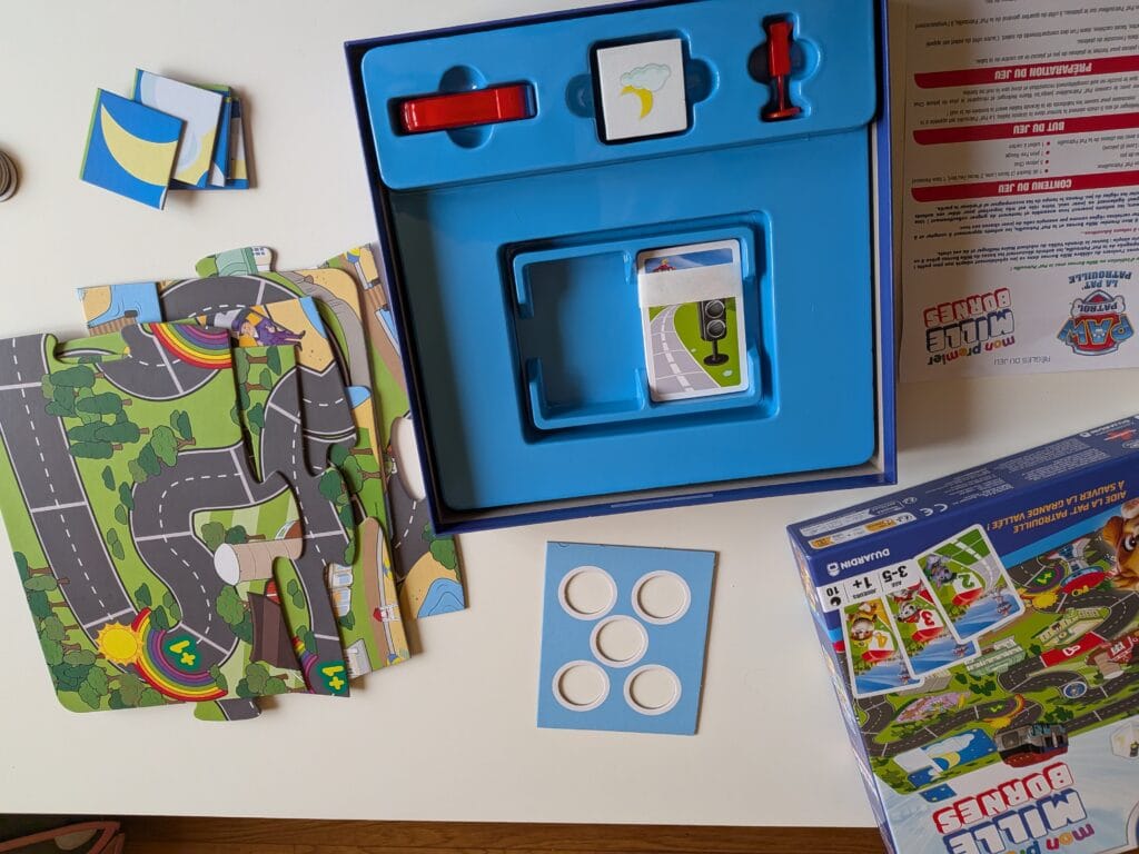 Jeu de société avec cartes, pièces et plateau de jeu coloré pour enfants.