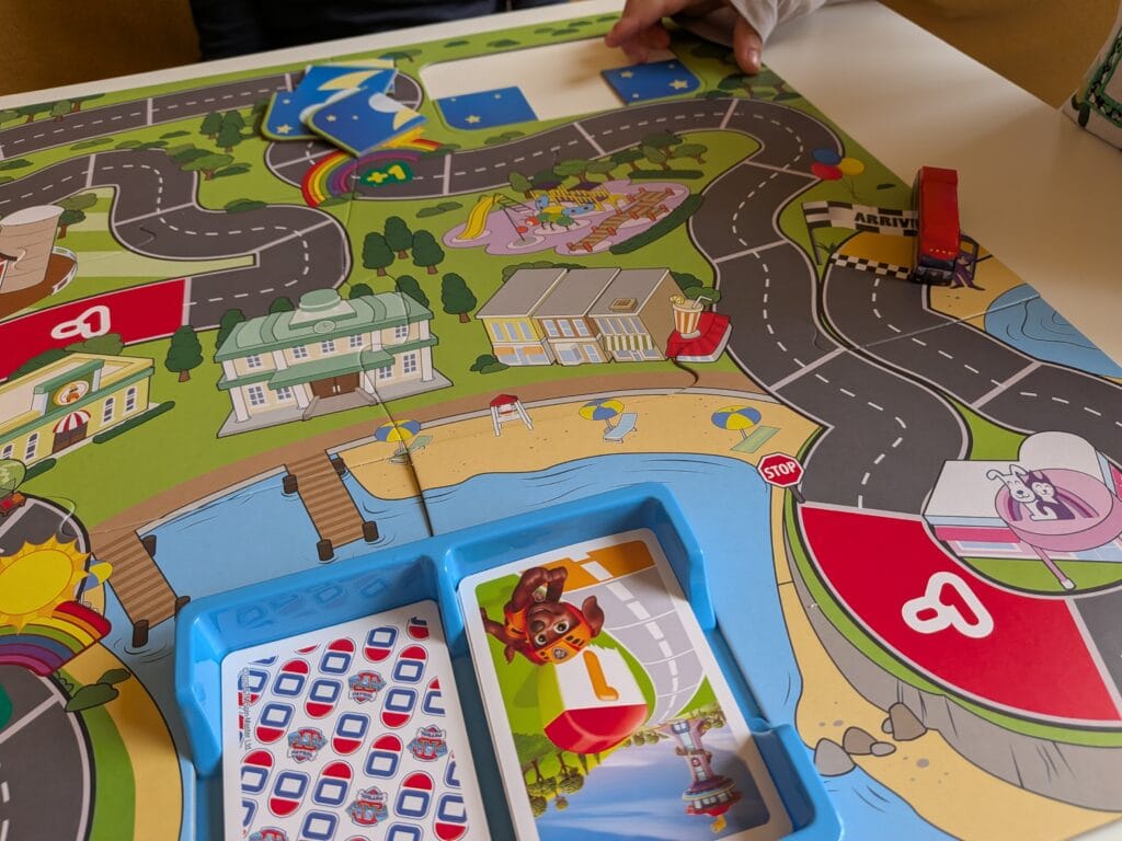 Jeu de société coloré avec routes, bâtiments et figurines pour enfants.