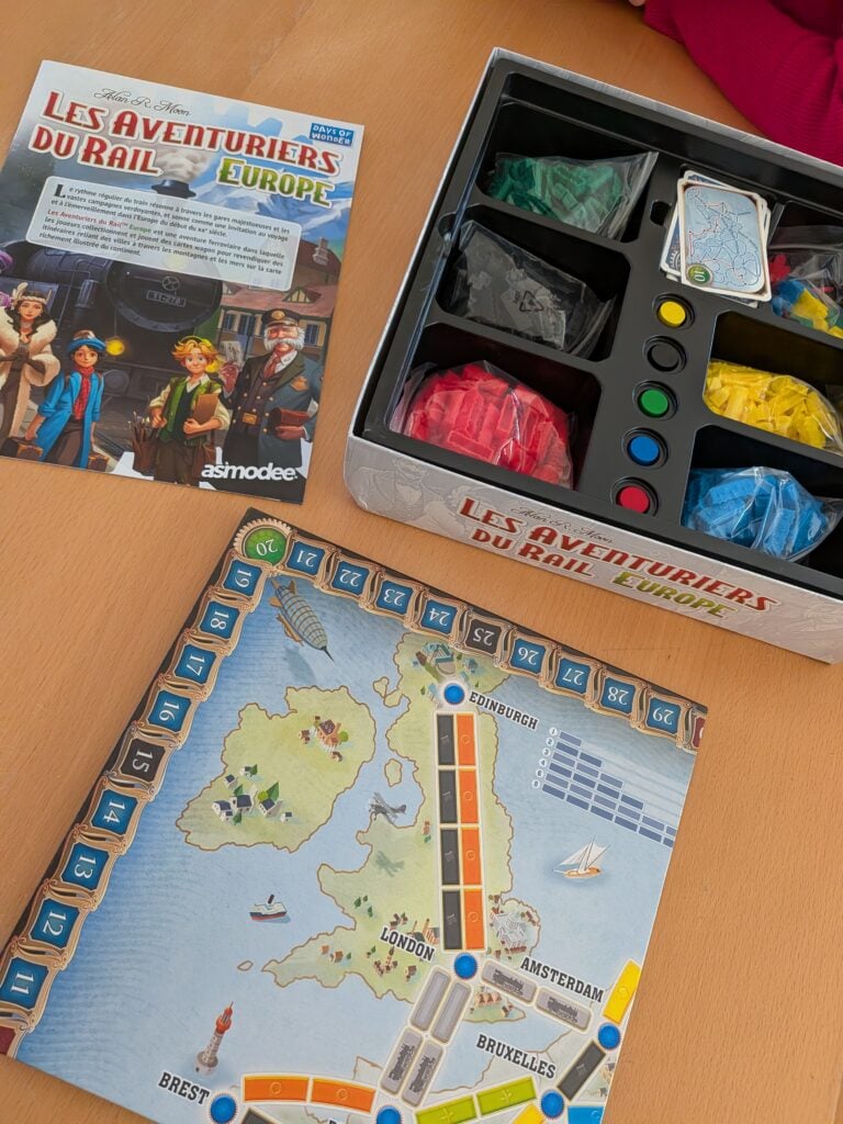 Jeu de société Les Aventuriers du Rail Europe avec plateau, trains en plastique et boîte de jeu ouverte.