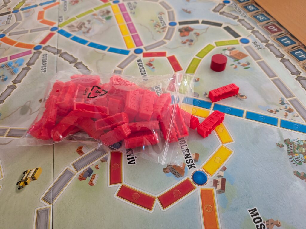 Jeu de société Les Aventuriers du Rail Europe avec pièces rouges et plateau coloré.