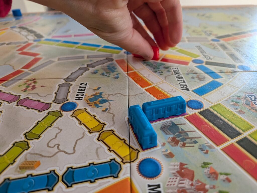 Jeu de société Les Aventuriers du Rail Europe avec pièces colorées et train en plastique sur plateau de jeu.