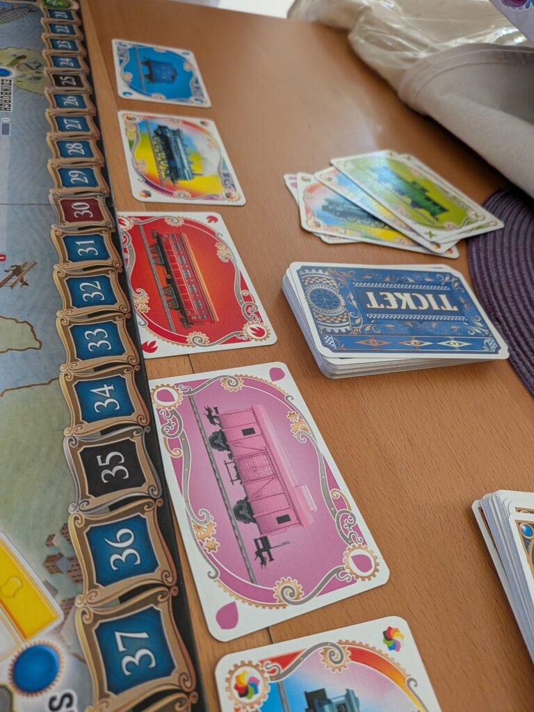 Jeu de société Les Aventuriers du Rail Europe avec cartes et wagons colorés sur une table en bois.