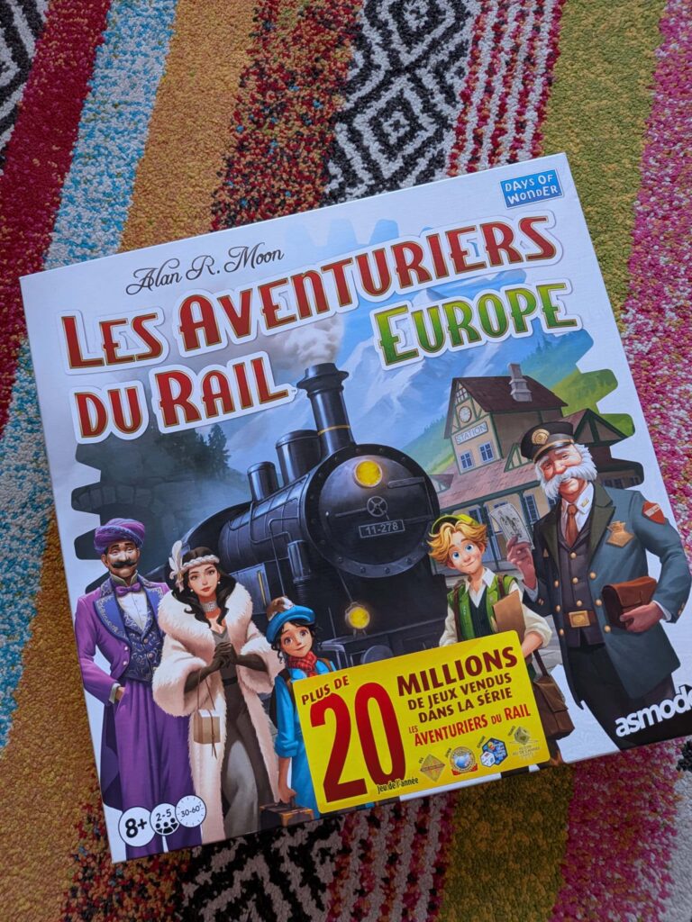 Couverture du jeu de société Les Aventuriers du Rail Europe avec personnages et train sur fond coloré.